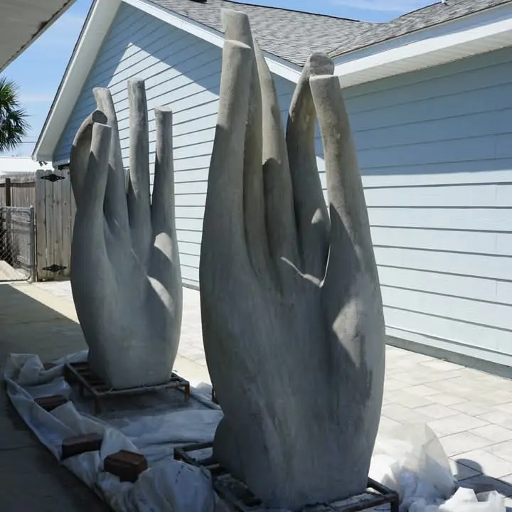 Hand-sculpted concrete memorial reef statues staged on land before their placement in the ocean.